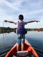 Young boy kayaking on a calm lake on a sunny day photo