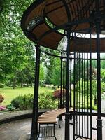 Elegant garden gazebo with wooden bench in lush park setting photo