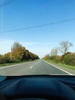 Sunny rural road view from inside car on a clear day photo