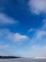 Winter landscape with blue sky and snow-covered fields photo