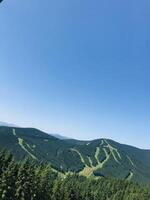 Panoramic view of lush green mountains under clear blue sky. Carpathian Mountains. photo