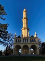 Tall historical tower minaret in Lednice under a clear blue sky at sunset, Czech Republic. photo