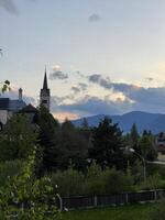 Charming village church and serene landscape at sunset in Austria photo