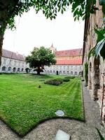 Historic courtyard with lush greenery and ancient architecture in Rajhrad, Czech Republic. photo