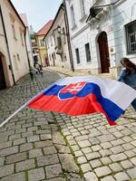 Slovakia flag waving on charming cobblestone street scene photo