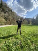 Man enjoys nature with open arms in scenic park photo