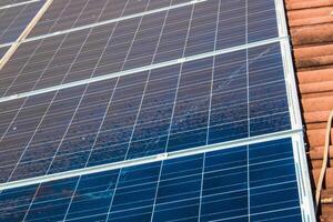 Solar worker cleaning photovoltaic panels with brush and water. Photovoltaic cleaning, before and after concept image. Space for text. photo