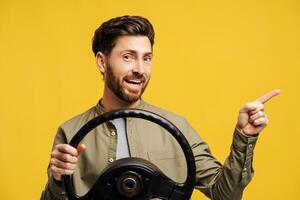 Portrait of smiling, handsome bearded man holding helm, pointing finger on copy space photo