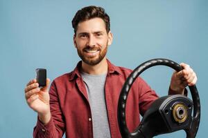 Portrait of smiling, happy bearded Latin man holding helm and car key, looking at camera photo