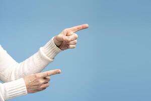 Closeup, senior woman pointing finger on copy space, selective focus on hands. Shopping concept photo