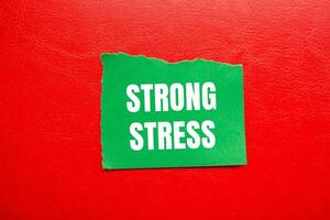 Strong stress message written on ripped torn green paper piece with red background. Conceptual strong stress symbol. Copy space. photo