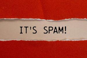 It's spam message written on ripped torn red paper with beige background. Conceptual it's spam symbol. Copy space. photo