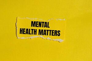 Mental health matters message written on ripped yellow torn paper piece with yellow background. Conceptual mental health matters symbol. Copy space. photo