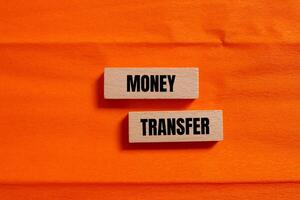 Money transfer message written on wooden blocks with orange background. Conceptual money transfer symbol. Copy space. photo
