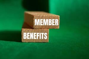 Member benefits message written on wooden blocks with green background. Conceptual member benefits symbol. Copy space. photo