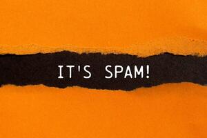 It's spam message written on ripped torn orange paper with black background. Conceptual it's spam symbol. Copy space. photo