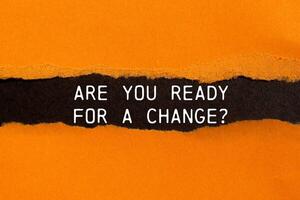 Are you ready for a change message written on ripped torn orange paper with black background. Conceptual are you ready for a change symbol. Copy space. photo