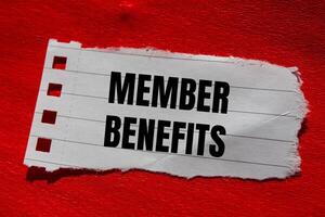Member benefits message written on ripped torn paper piece with red background. Conceptual member benefits symbol. Copy space. photo