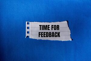 Time for feedback message written on ripped torn paper piece with blue background. Conceptual time for feedback symbol. Copy space. photo