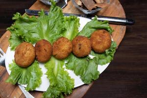 mashed potatoes with chicken cutlets and greens on a dark background top view photo