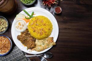 Beef Bhuna Khichuri rice with egg, kheer, and salad served in a dish isolated on the background top view of Bangladesh food photo