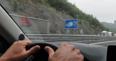 Driver is holding the steering wheel while driving on a highway in various weather and traffic conditions video