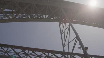 närbild se av de strukturera av en stor järn bro med solljus lysande genom video