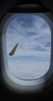 Scenic view from an airplane window with a blue sky with scattered wispy clouds video