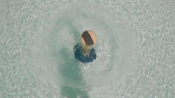 Top-down view of a circular water fountain with rippling water patterns surrounding a central spout casting a shadow on the water surface video