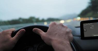 Adjusting hand position on the steering wheel while driving along a highway showcases focus and control in a vehicle video