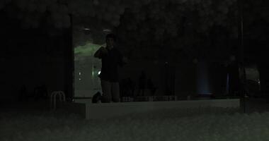 BARCELONA, SPAIN - JULY 27, 2024. Visitors exploring a darkened art installation with clusters of balloons at the Balloon Museum Pop Air event, creating a mysterious and ambient atmosphere video