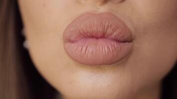 Extreme close-up plump female sexy lips wearing nude lipstick making kiss and smiling video