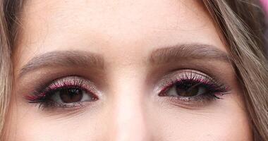 Pretty woman with make up and eyelashes looking at camera. video