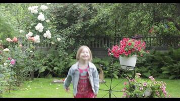Girl child having fun in the rain. a little girl running around having fun in the rain in the yard at home video