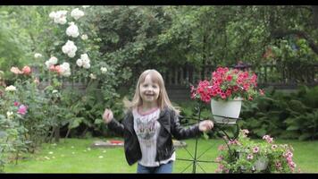 Children have fun in the rain. Two sisters are running around having fun in the rain in the yard at home. video
