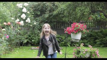 Girl child having fun in the rain. a little girl running around having fun in the rain in the yard at home video