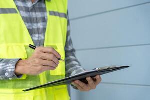 inspector or engineer is inspecting construction and quality assurance new house using a checklist. Engineers or architects or contactor work to build the house before handing it over to the homeowner photo