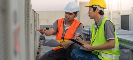 Engineers use blueprint check air condition systems on site. Contractor and inspector inspection compressor during project. maintenance team check quality assurance. Audit, inspect, quality control. photo