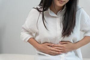 stomach ache. Asian women have abdominal pain, indigestion, gastritis, menstrual cramps, flatulence, diarrhea, distention, colon cancer, belly inflammation problem, suffer food poisoning, abdomen photo
