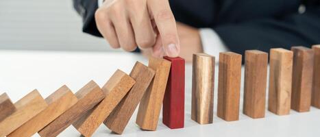 insurance with hands protect domino. Businessman hands stop dominoes falling in business crisis. business risk control and planning and strategies to run prevent insurance businesses. photo