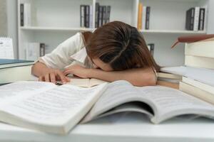 Asian student woman have anxiety because of exams, female prepare for test and learning lessons in the library. stress, despair, haste, misunderstanding reading, discouraged, expectation, knowledge photo