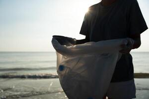 Save ocean. Volunteer pick up trash garbage at the beach and plastic bottles are difficult decompose prevent harm aquatic life. Earth, Environment, Greening planet, reduce global warming, Save world photo