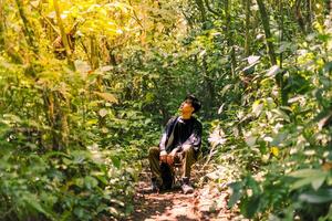Man Resting in the Wilderness, Immersed in the Beauty of Nature. Calm and Pristine Mountain Forest Landscape. photo