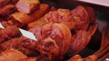 Matured and smoked pieces of meat with bones in a window shop. video