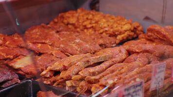 Large range of seasoned meat with spices and herbs in showcase in shop. video
