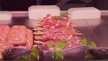 Lamb meat cuts on skewers in a supermarket layout in window shop. video
