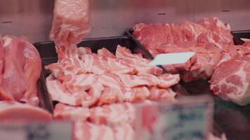 Close-up of salesman lays out the raw meat into the pallet for window display. video