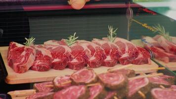 Raw marbled beef steaks in show case and ready for frying. video