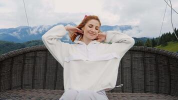 Portrait of woman on a swing with the view to the mountains. video