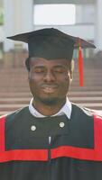 Portrait of smiling student graduate near university. Vertical video
